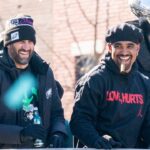 Philadelphia Eagles owner, Jeffrey Lurie, left, joins head coach Nick Sirianni and quarterback Jalen Hurts atop one of the team buses during the Super Bowl 59 victory parade along S. Broad Street in Philadelphia, PA, on Friday, Feb. 14, 2025.