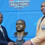 Aug 6, 2022; Canton, OH, USA; Richard Seymour (right) and presenter Titus Duren pose with bust of Seymour during the Pro Football Hall of Fame Class of 2022 Enshrinement at Tom Benson Hall of Fame Stadium.