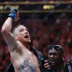Justin Gaethje (blue gloves) reacts to defeating Dustin Poirier (red gloves) during UFC 291 at Delta Center.