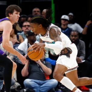 Memphis Grizzlies guard Ja Morant (12) drives to the basket around Los Angeles Lakers guard Austin Reaves (15) during the first half at FedExForum
