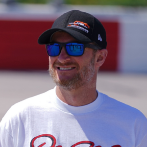 Former NASCAR driver Dale Earnhardt Jr. poses for a picture with the restored 1984 Chevy Nova driven by his father the late Dale Earnhardt Sr. on pit road prior to the Steakhouse Elite 200 at Darlington Raceway.