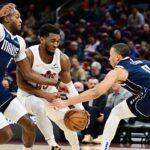 Cleveland Cavaliers guard Donovan Mitchell (45) drives to the basket between Dallas Mavericks forward Olivier-Maxence Prosper (8) and guard Dante Exum (0) during the second half at Rocket Mortgage FieldHouse.