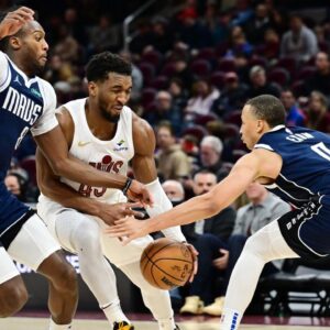 Cleveland Cavaliers guard Donovan Mitchell (45) drives to the basket between Dallas Mavericks forward Olivier-Maxence Prosper (8) and guard Dante Exum (0) during the second half at Rocket Mortgage FieldHouse.