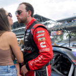 Jul 30, 2022; Speedway, Indiana, USA; NASCAR Xfinity Series driver Chase Briscoe (07) kisses his wife before the Penzoil 150 at the Indianapolis Motor Speedway Road Course. Mandatory Credit: Marc Lebryk-Imagn Images