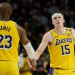 Los Angeles Lakers guard Austin Reaves (15) high fives forward LeBron James (23) during the second half against the Portland Trail Blazers at Moda Center.