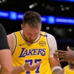 Los Angeles Lakers forward LeBron James (23) checks on guard Luka Doncic (77) after he was hit in the face against the Utah Jazz at Crypto.com Arena.