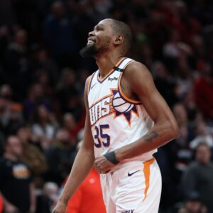 Phoenix Suns forward Kevin Durant (35) laughs as he watches a replay of his teammate Suns’ guard Devin Booker (1) being fouled by Portland Trail Blazers forward Deni Avdija (8) in overtime at Moda Center.