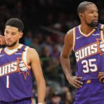 Phoenix Suns guard Devin Booker (1) and Phoenix Suns forward Kevin Durant (35) look on against the Brooklyn Nets during the second half at Footprint Center.