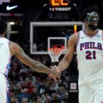 Philadelphia 76ers center Joel Embiid (21) and forward Paul George (8) high five during the second half against the Portland Trail Blazers at Moda Center.