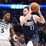 Dallas Mavericks guard Luka Doncic (77) dribbles against Minnesota Timberwolves guard Anthony Edwards (5) during the third quarter of game four of the western conference finals for the 2024 NBA playoffs at American Airlines Center