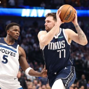 Dallas Mavericks guard Luka Doncic (77) dribbles against Minnesota Timberwolves guard Anthony Edwards (5) during the third quarter of game four of the western conference finals for the 2024 NBA playoffs at American Airlines Center