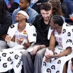 Oklahoma City Thunder guard Cason Wallace (22), guard Shai Gilgeous-Alexander (2), forward Chet Holmgren (7) and forward Jalen Williams (8) watch the game against the Phoenix Suns from the bench during the fourth quarter of a game at Paycom Center.