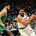 New York Knicks center Karl-Anthony Towns (32) controls the ball while Boston Celtics forward Jayson Tatum (0) defends during the first half at TD Garden.