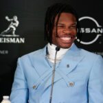 Colorado Buffaloes wide receiver/cornerback Travis Hunter smiles on stage during a press conference before the 2024 Heisman Trophy Presentation.