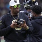 Colorado Buffaloes head coach Deion Sanders walks on the field between plays during the first quarter against the Brigham Young Cougars at Alamodome.
