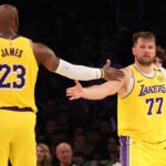 Los Angeles Lakers forward LeBron James (23) and guard Luka Doncic (77) celebrate after a play during the third quarter against the Charlotte Hornets at Crypto.com Arena