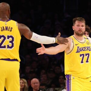 Los Angeles Lakers forward LeBron James (23) and guard Luka Doncic (77) celebrate after a play during the third quarter against the Charlotte Hornets at Crypto.com Arena