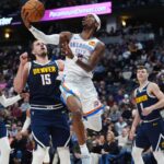 Oklahoma City Thunder guard Shai Gilgeous-Alexander (2) shoots the ball past Denver Nuggets center Nikola Jokic (15) in the second quarter at Ball Arena.