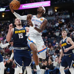 Oklahoma City Thunder guard Shai Gilgeous-Alexander (2) shoots the ball past Denver Nuggets center Nikola Jokic (15) in the second quarter at Ball Arena.