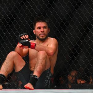 Henry Cejudo (red gloves) sits down after being poked in the eye by Song Yadong (blue gloves) in the bantamweight bout during UFC Fight Night at Climate Pledge Arena.
