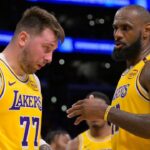 Los Angeles Lakers forward LeBron James (23) checks on guard Luka Doncic (77) after he was hit in the face against the Utah Jazz at Crypto.com Arena