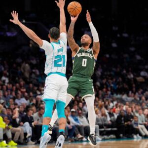 Milwaukee Bucks guard Damian Lillard (0) shoots the jumper over Charlotte Hornets guard KJ Simpson (25) during the second quarter at Spectrum Center.