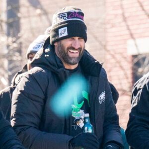 Philadelphia Eagles owner Jeffrey Lurie, left, joins head coach Nick Sirianni and quarterback Jalen Hurts atop one of the team buses during the Super Bowl 59 victory parade along South Broad Street in Philadelphia on Friday, Feb. 14, 2025.