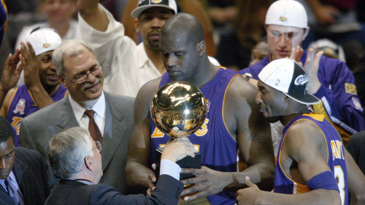 NBA commissioner David Stern hands Los Angeles Lakers Phil Jackson (left), Shaquille O'Neal (center) and Kobe Bryant (right) their championship trophy at the end of Game 4 of the NBA Finals at The Meadowlands.
