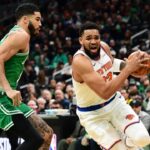 New York Knicks center Karl-Anthony Towns (32) controls the ball while Boston Celtics forward Jayson Tatum (0) defends during the first half at TD Garden.