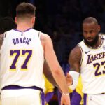 Los Angeles Lakers forward LeBron James (23) and guard Luka Doncic (77) react after a play during the first quarter against the LA Clippers at Crypto.com Arena.