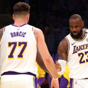 Los Angeles Lakers forward LeBron James (23) and guard Luka Doncic (77) react after a play during the first quarter against the LA Clippers at Crypto.com Arena.