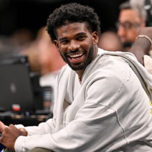 Colorado Buffaloes quarterback Shedeur Sanders laughs as he watches the game between the Dallas Mavericks and the Denver Nuggets during the second half at the American Airlines Center.