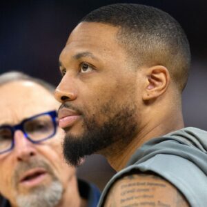 Milwaukee Bucks guard Damian Lillard (right) chats up Golden State Warriors assistant coach Ron Adams before a game at Chase Center.