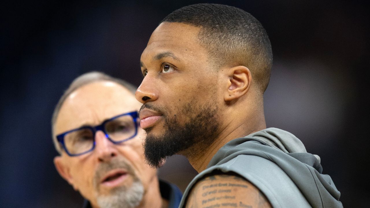 Milwaukee Bucks guard Damian Lillard (right) chats up Golden State Warriors assistant coach Ron Adams before a game at Chase Center.
