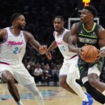 Minnesota Timberwolves guard Anthony Edwards (5) looks for a passing lane as Miami Heat forward Haywood Highsmith (24) and guard Davion Mitchell (45) defend during the second half at Kaseya Center.
