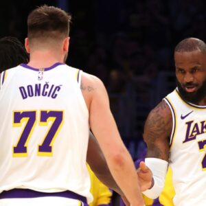 Los Angeles Lakers forward LeBron James (23) and guard Luka Doncic (77) react after a play during the first quarter against the LA Clippers at Crypto.com Arena.