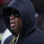 Colorado Buffaloes head coach Deion Sanders jogs on the field before the game against the Brigham Young Cougars at Alamodome.