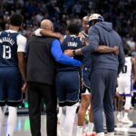 Dallas Mavericks guard Kyrie Irving (11) is helped off the court by forward Naji Marshall (13) and forward Anthony Davis (3) during the second quarter against the Sacramento Kings at the American Airlines Center.