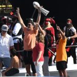 Tampa Bay Buccaneers quarterback Tom Brady celebrates with the Vince Lombardi Trophy on his boat during the Tampa Bay Buccaneers boat parade to celebrate their victory over the Kansas City Chiefs in Super Bowl LV.
