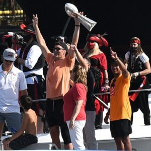 Tampa Bay Buccaneers quarterback Tom Brady celebrates with the Vince Lombardi Trophy on his boat during the Tampa Bay Buccaneers boat parade to celebrate their victory over the Kansas City Chiefs in Super Bowl LV.