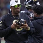 Colorado Buffaloes head coach Deion Sanders walks on the field between plays during the first quarter against the Brigham Young Cougars at Alamodome.