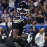 Dec 28, 2024; San Antonio, TX, USA; Colorado Buffaloes wide receiver Travis Hunter (12) runs with the ball and scores a touchdown during the third quarter against the Brigham Young Cougars at Alamodome.