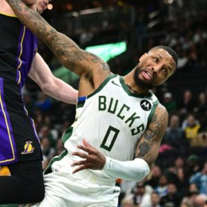 Milwaukee Bucks guard Damian Lillard (0) is fouled by Los Angeles Lakers forward Dalton Knecht (4) in the second quarter at Fiserv Forum.