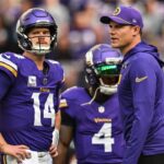 Minnesota Vikings quarterback Sam Darnold (14) and Minnesota Vikings head coach Kevin O'Connell and fullback C.J. Ham (right) look on before the game against the Detroit Lions at U.S. Bank Stadium.