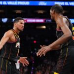 Phoenix Suns guard Devin Booker (1) and Phoenix Suns forward Kevin Durant (35) slap hands against the Cleveland Cavaliers during the second half at Footprint Center.
