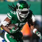 Dec 22, 2024; East Rutherford, New Jersey, USA; New York Jets wide receiver Davante Adams (17) fights for yards as Los Angeles Rams safety Quentin Lake (37) tackles during the first half at MetLife Stadium.