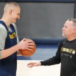 Denver Nuggets center Nikola Jokic (15) talks with head coach Michael Malone during a practice session on media day before the 2023 NBA Finals at Ball Arena.