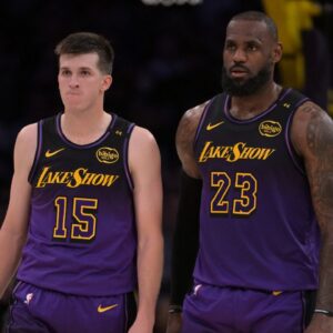 Los Angeles Lakers guard Austin Reaves (15) and forward LeBron James (23) talk on the court during a stoppage in play against the Orlando Magic at Crypto.com Arena.