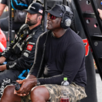 Apr 6, 2025; Darlington, South Carolina, USA; NASCAR Cup Series driver Tyler Reddick (45) team owner Michael Jordan watches his racer during the Goodyear 400 at Darlington Raceway. Mandatory Credit: Jim Dedmon-Imagn Images