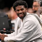 Colorado Buffaloes quarterback Shedeur Sanders laughs as he watches the game between the Dallas Mavericks and the Denver Nuggets during the second half at the American Airlines Center.